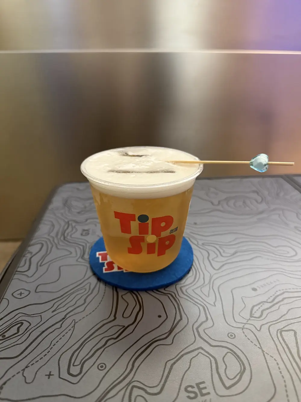 A TipSip cocktail on a blue coaster